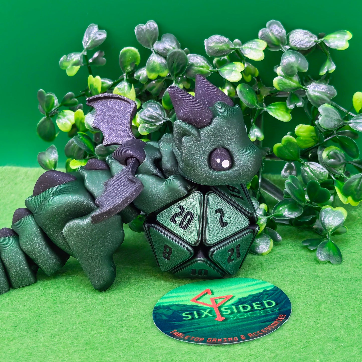 3D printed articulated baby dragon figurine for tabletop gaming – perfect Dungeons & Dragons gift, RPG accessory, and fantasy desk decor. Multi‑colour PLA dragon with movable wings and tail for fidget play during D&D, Pathfinder, and TTRPG campaigns. Ideal gamer gift for Dungeon Masters, dice collectors, and fantasy enthusiasts – handcrafted by Six Sided Society in Coventry, UK.
