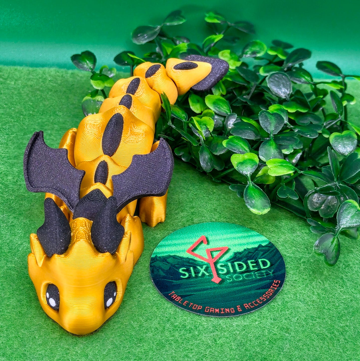 3D printed articulated baby dragon figurine for tabletop gaming – perfect Dungeons & Dragons gift, RPG accessory, and fantasy desk decor. Multi‑colour PLA dragon with movable wings and tail for fidget play during D&D, Pathfinder, and TTRPG campaigns. Ideal gamer gift for Dungeon Masters, dice collectors, and fantasy enthusiasts – handcrafted by Six Sided Society in Coventry, UK.