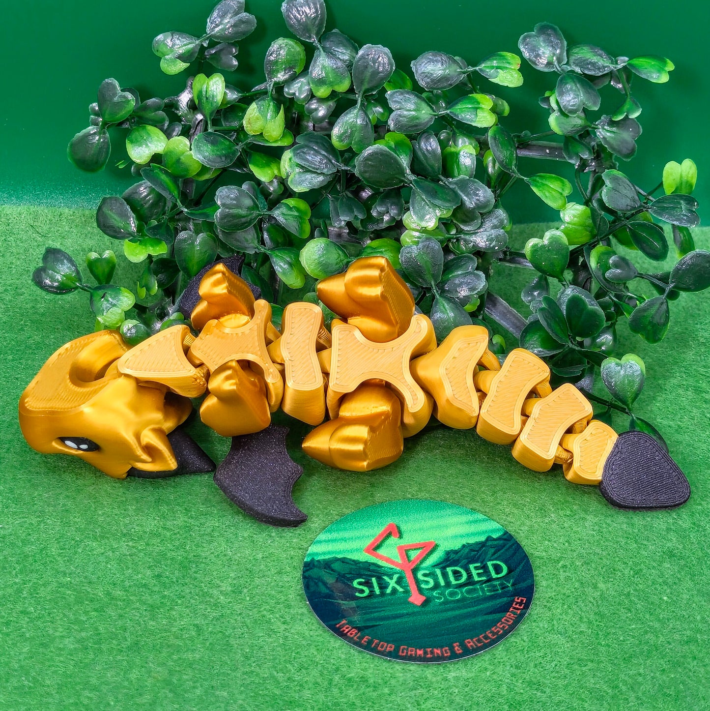 3D printed articulated baby dragon figurine for tabletop gaming – perfect Dungeons & Dragons gift, RPG accessory, and fantasy desk decor. Multi‑colour PLA dragon with movable wings and tail for fidget play during D&D, Pathfinder, and TTRPG campaigns. Ideal gamer gift for Dungeon Masters, dice collectors, and fantasy enthusiasts – handcrafted by Six Sided Society in Coventry, UK.