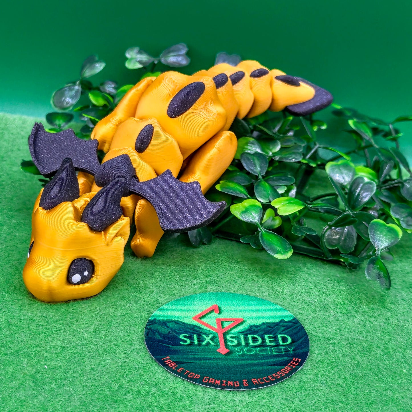 3D printed articulated baby dragon figurine for tabletop gaming – perfect Dungeons & Dragons gift, RPG accessory, and fantasy desk decor. Multi‑colour PLA dragon with movable wings and tail for fidget play during D&D, Pathfinder, and TTRPG campaigns. Ideal gamer gift for Dungeon Masters, dice collectors, and fantasy enthusiasts – handcrafted by Six Sided Society in Coventry, UK.