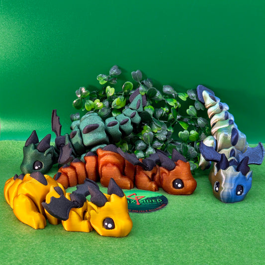 3D printed articulated baby dragon figurine for tabletop gaming – perfect Dungeons & Dragons gift, RPG accessory, and fantasy desk decor. Multi‑colour PLA dragon with movable wings and tail for fidget play during D&D, Pathfinder, and TTRPG campaigns. Ideal gamer gift for Dungeon Masters, dice collectors, and fantasy enthusiasts – handcrafted by Six Sided Society in Coventry, UK.
