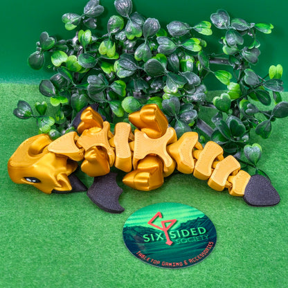 3D printed articulated baby dragon figurine for tabletop gaming – perfect Dungeons & Dragons gift, RPG accessory, and fantasy desk decor. Multi‑colour PLA dragon with movable wings and tail for fidget play during D&D, Pathfinder, and TTRPG campaigns. Ideal gamer gift for Dungeon Masters, dice collectors, and fantasy enthusiasts – handcrafted by Six Sided Society in Coventry, UK.